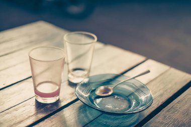 Boş bardak sıcak çay fincan tabağı ve ahşap masa kaşık 