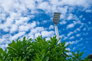 Mavi gökyüzü arka plan ve ağaç ile lamba sonrası Elektrik Sanayi