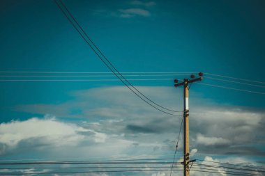 Mavi gökyüzü ile yüksek voltajlı elektrik direği