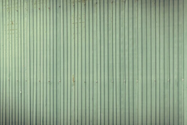 green corrugated metal wall or fence.