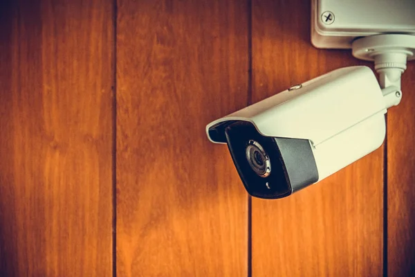 Cámara de seguridad o cámara CCTV en la pared de madera en la habitación . — Foto de Stock