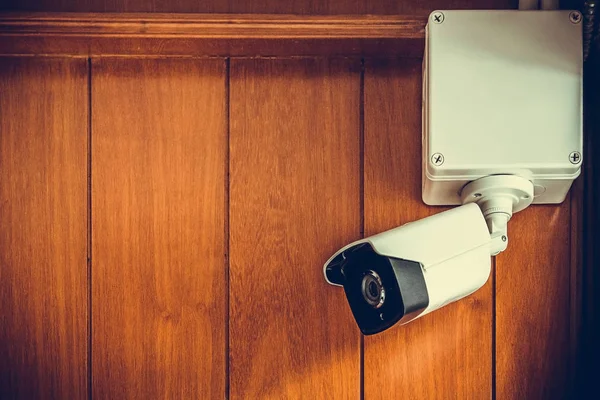 Caméra de sécurité ou caméra de vidéosurveillance sur un mur en bois dans la pièce . — Photo