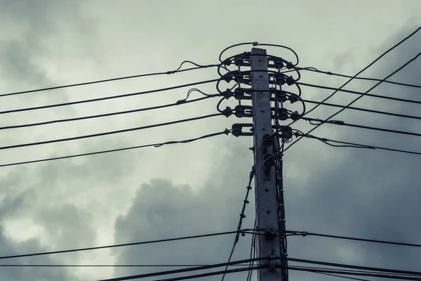 Poste de alta tensión con cables enredados en el edificio detrás . — Foto de Stock