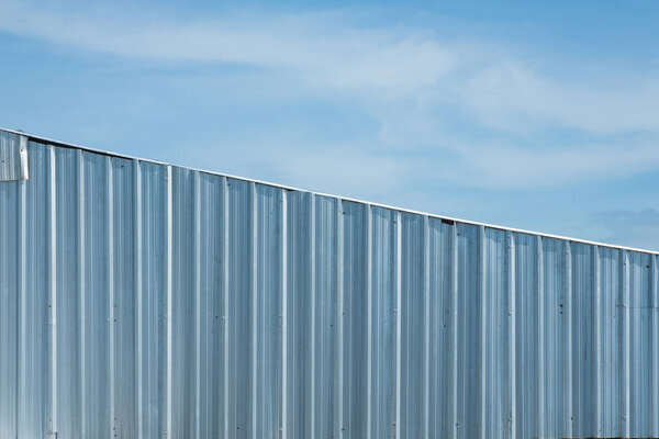 Silver metal sheet wall, aluminium corrugate wall background with blue sky
