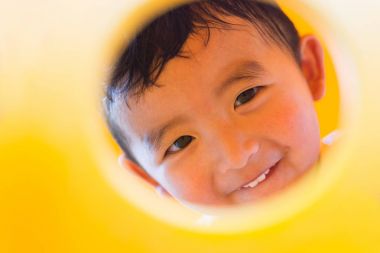 Oynama ve playg, sarı tünelde gülümseyen sevimli Asya çocuk