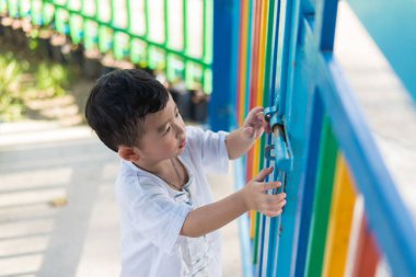 Üzgün Asyalı çocuk kaçmaya çalışırken ızgara arkasında. sığ Dof