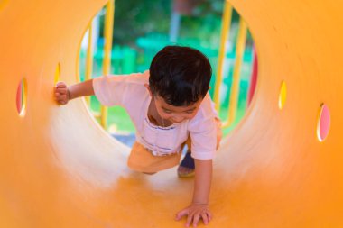 Oynama ve playg, sarı tünelde gülümseyen sevimli Asya çocuk