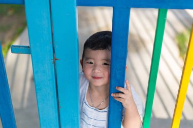 Asyalı Çocuk Bahçesi summe içinde renkli çitte arkasında gülümse