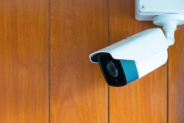 Cámara de seguridad o cámara CCTV en la pared de madera en la habitación . —  Fotos de Stock