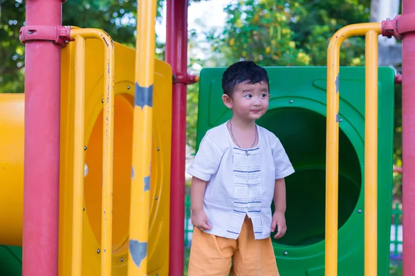 Malé Asijské dítě hrát a usmívá se na hřišti pod — Stock fotografie