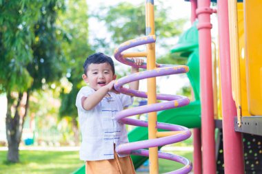 Okul bahçesinde bahar metal tırmanma oynayan etkin küçük çocuk