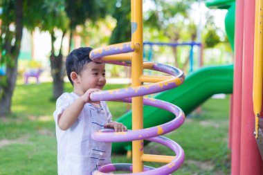 Okul bahçesinde bahar metal tırmanma oynayan etkin küçük çocuk