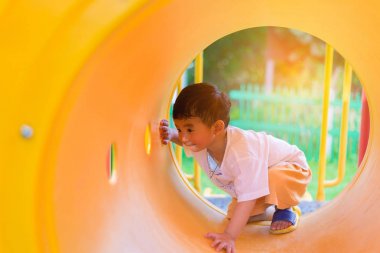 Oynama ve playg, sarı tünelde gülümseyen sevimli Asya çocuk