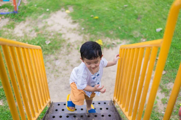O miúdo asiático sobe as escadas do parque. conceito de crescer . — Fotografia de Stock