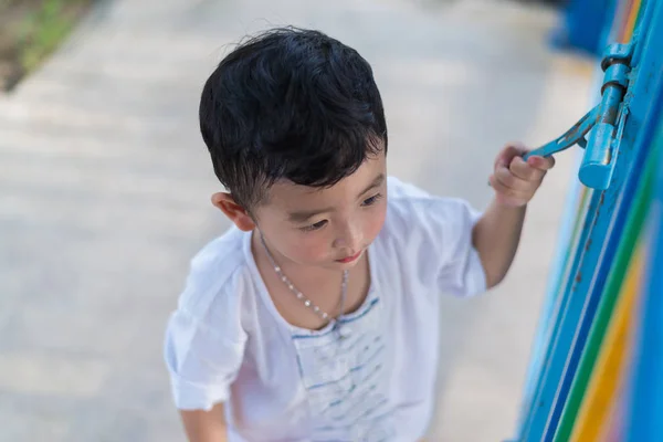 Smutné, Asijské dítě za mřížkou, se snaží uniknout. mělké Dof — Stock fotografie