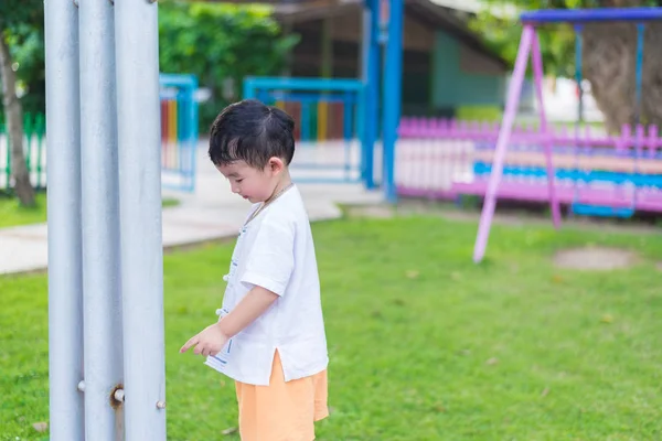 Little Asian kid playing and smiling at the playground under the — Stock Photo, Image