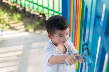 Asyalı Çocuk Bahçesi summe içinde renkli çitte arkasında gülümse