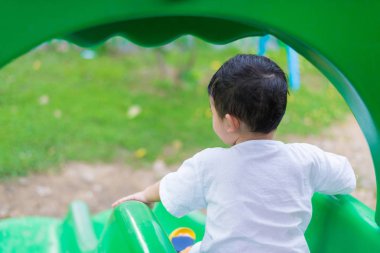 Küçük Asyalı Çocuk Bahçesi sunli altında slayt oynayan