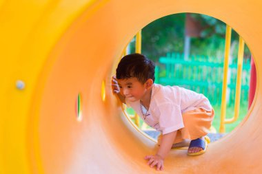 Oynama ve playg, sarı tünelde gülümseyen sevimli Asya çocuk