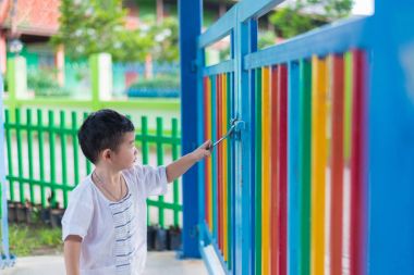 Üzgün Asyalı çocuk kaçmaya çalışırken ızgara arkasında. sığ Dof