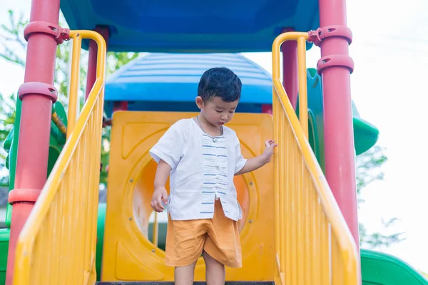 Asiático chico va abajo la escaleras en el parque . — Foto de Stock