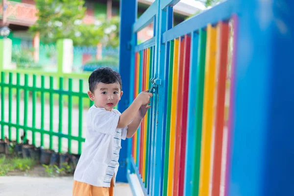 Üzgün Asyalı çocuk kaçmaya çalışırken ızgara arkasında. sığ Dof
