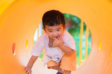 Oynama ve playg, sarı tünelde gülümseyen sevimli Asya çocuk