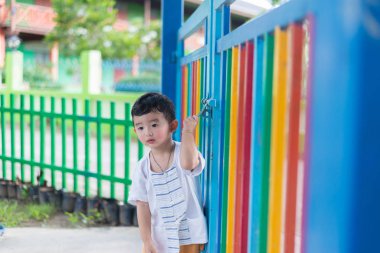 Üzgün Asyalı çocuk kaçmaya çalışırken ızgara arkasında. sığ Dof