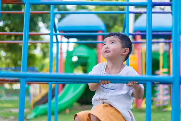 Asiático chico colgar el metal bar en al aire libre parque infantil . — Foto de Stock