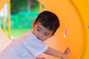 Oynama ve playg, sarı tünelde gülümseyen sevimli Asya çocuk