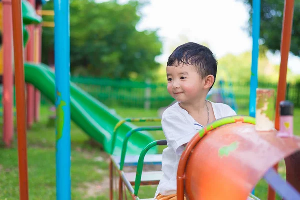Jovem ásia menino jogar um ferro trem balançando no o playground und — Fotografia de Stock