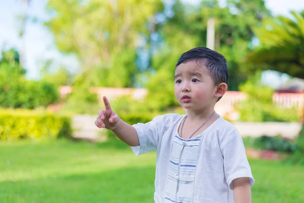 Asian little Kid pointing up by fingers to something or empty co — Stock Photo, Image