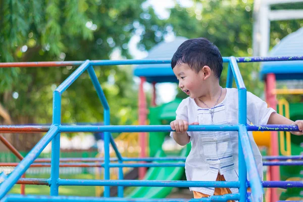 Asiático chico colgar el metal bar en al aire libre parque infantil . — Foto de Stock