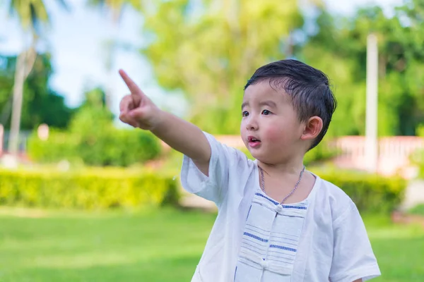 Asian little Kid pointing up by fingers to something or empty co — Stock Photo, Image