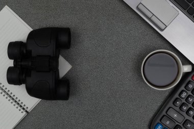 Dizüstü bilgisayar ya da defter, dürbün ve kahve çalışma