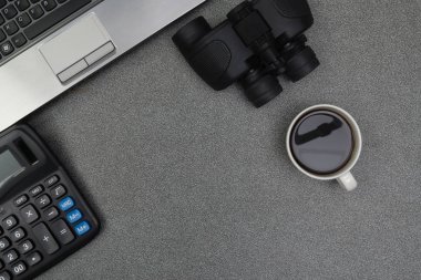 Dizüstü bilgisayar ya da defter ve dürbün, hesap makinesi ve fincan