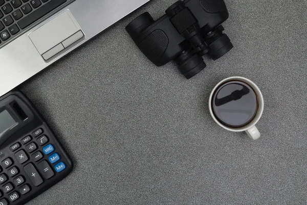 Dizüstü bilgisayar ya da defter ve dürbün, hesap makinesi ve fincan