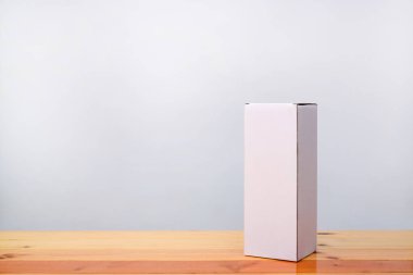 Ahşap masa uzun maddelerle boş paket beyaz karton kutu