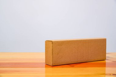 Ahşap masa uzun maddelerle boş paket kahverengi karton kutu