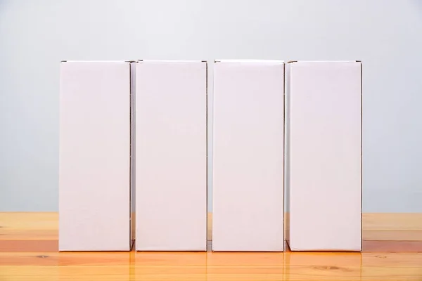 Üres négy csomag fehér karton doboz hosszú cikkek fából — Stock Fotó