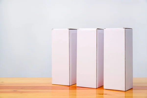 Opróżnić trzy pakiet biały karton dla długich przedmiotów na drewniane — Zdjęcie stockowe