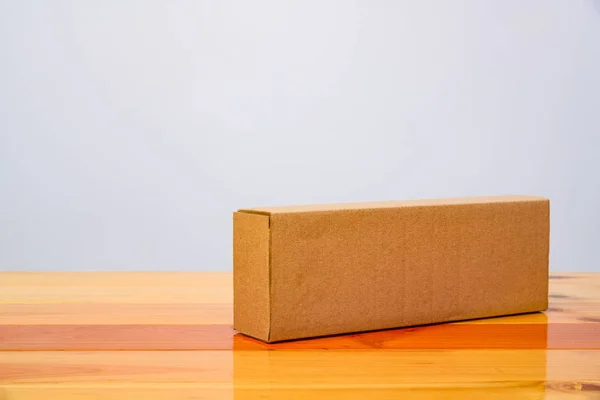 Пустой пакет коричневый картонный ящик для длинных предметов на деревянный стол — стоковое фото
