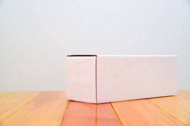 Ahşap masa uzun maddelerle boş paket beyaz karton kutu