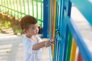 Üzgün Asyalı çocuk kaçmaya çalışırken ızgara arkasında. sığ Dof