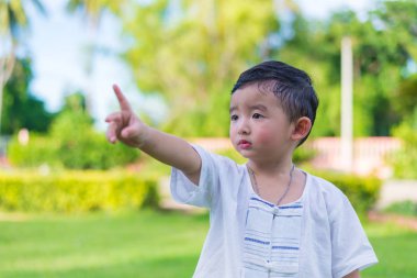 Asyalı küçük çocuk tarafından işaret parmakları bir şey veya boş co