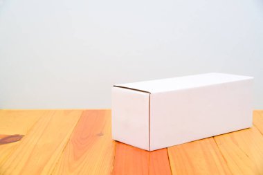 Ahşap masa uzun maddelerle boş paket beyaz karton kutu