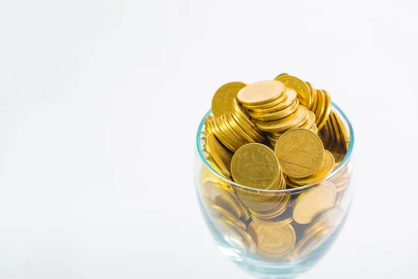 Moedas de ouro em uma taça de champanhe, no fundo branco . — Fotografia de Stock