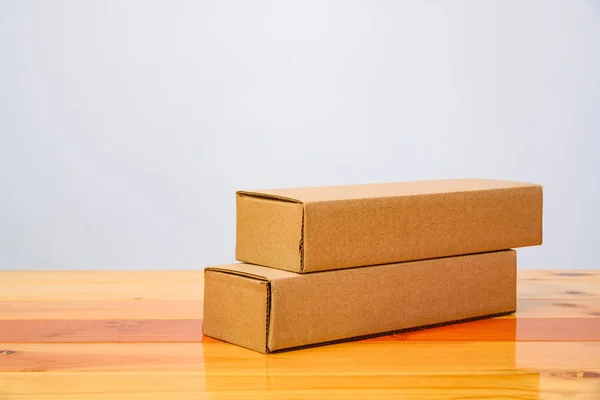 Caja de cartón marrón vacía de dos paquetes para artículos largos en t de madera — Foto de Stock