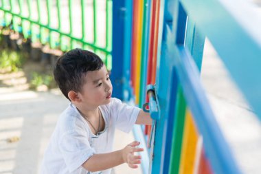 Üzgün Asyalı çocuk kaçmaya çalışırken ızgara arkasında. sığ Dof