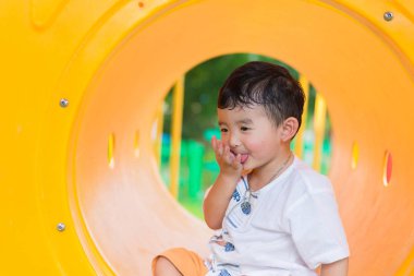 Oynama ve playg, sarı tünelde gülümseyen sevimli Asya çocuk